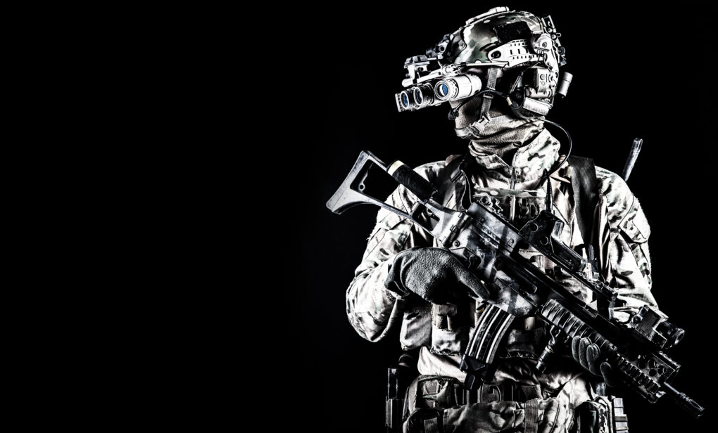 Soldier in night vision device on black background